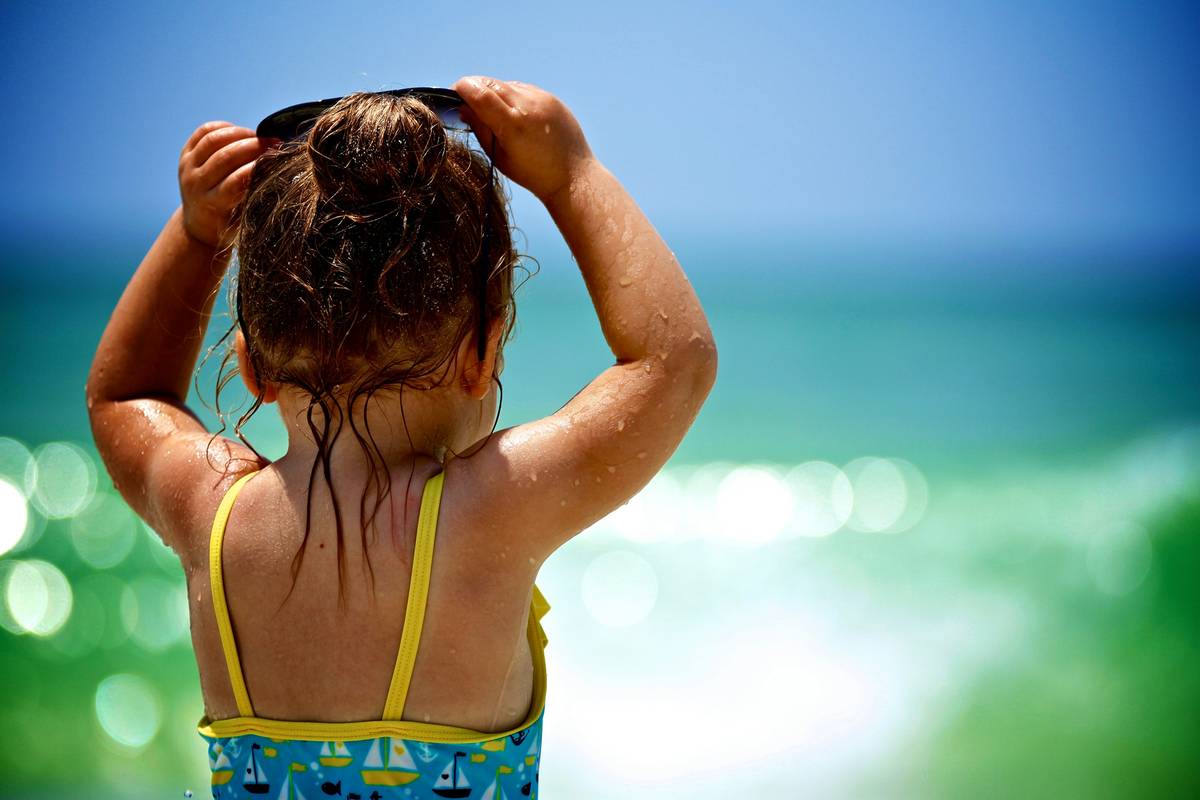 Mother carefully applying sunscreen on toddler's face using how to apply sunscreen for kids technique