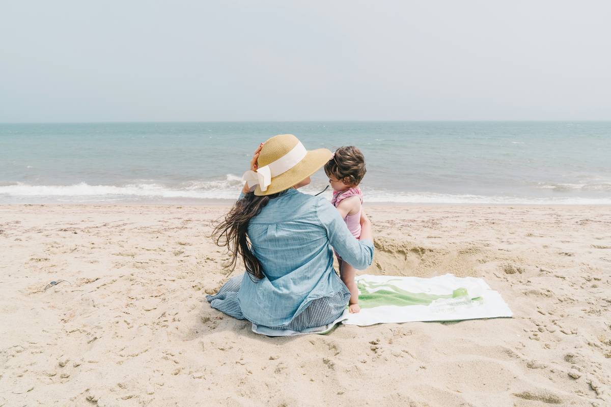 Daycare staff reapplying sunscreen on multiple children during outdoor play following how to apply sunscreen in childcare guidelines