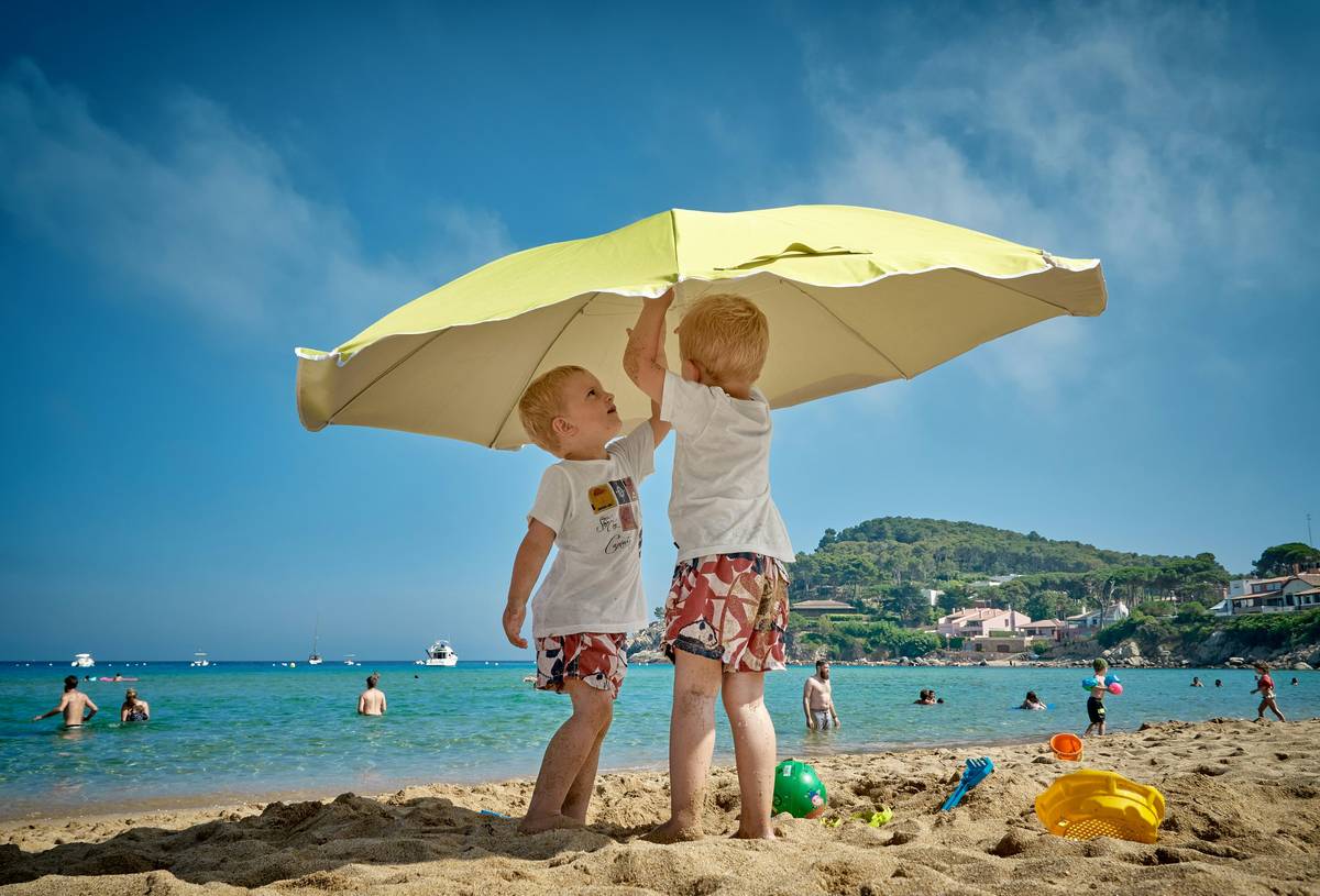 Close-up of applying baby sunscreen on child's ears and back of neck demonstrating how to apply sunscreen for kids correctly